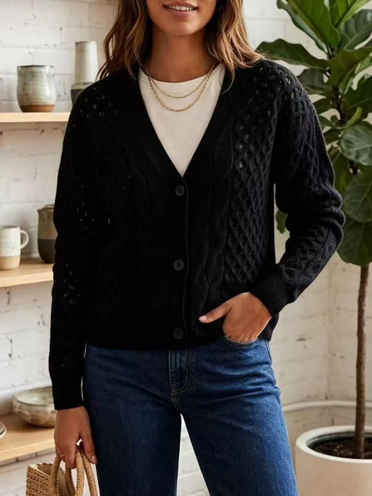 Black cable-knit v-neck button-front cardigan, front view.