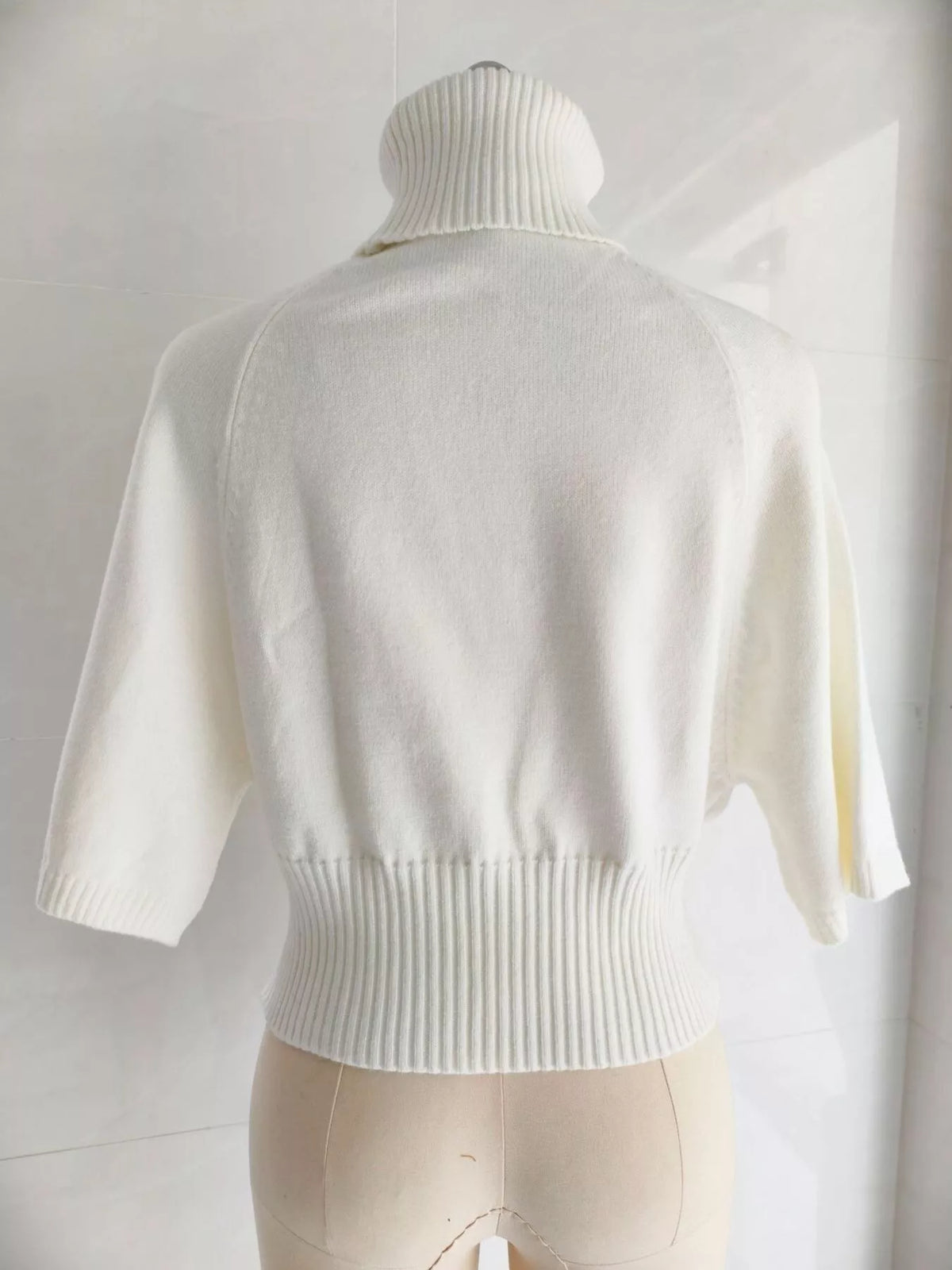Turtleneck batwing top, cream mannequin back