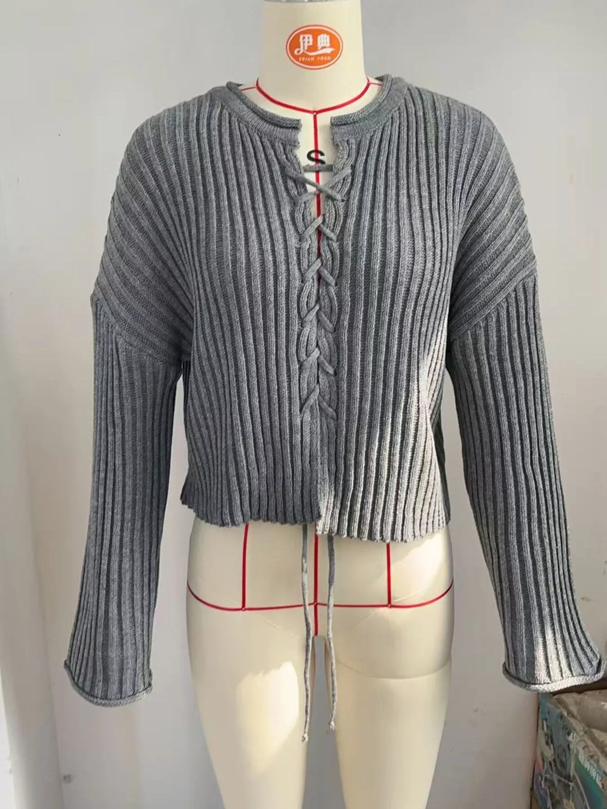 Gray ribbed lace-up cropped sweater, front on dress form.