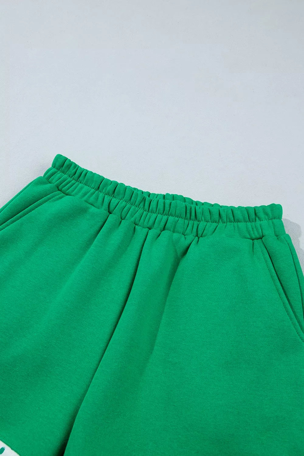 Green sweatshirt and shorts set with polka-dot trim, shorts waist detail