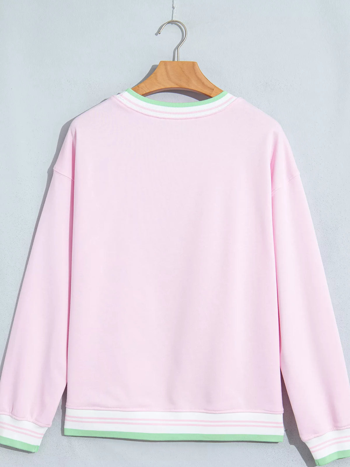 Pink sweatshirt with contrast striped ribbed trim, back view