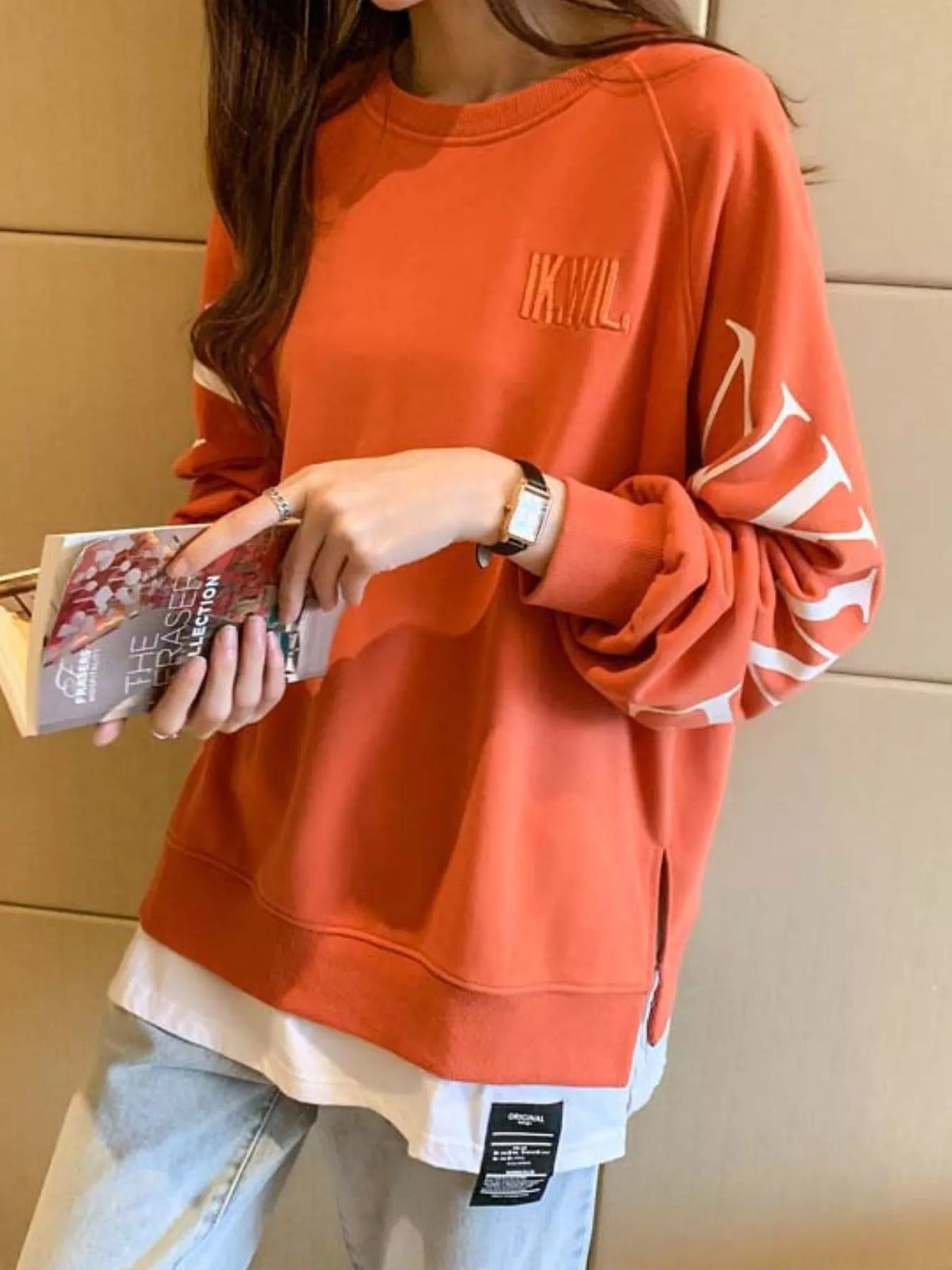 Orange layered-hem sweatshirt with graphic sleeve detail