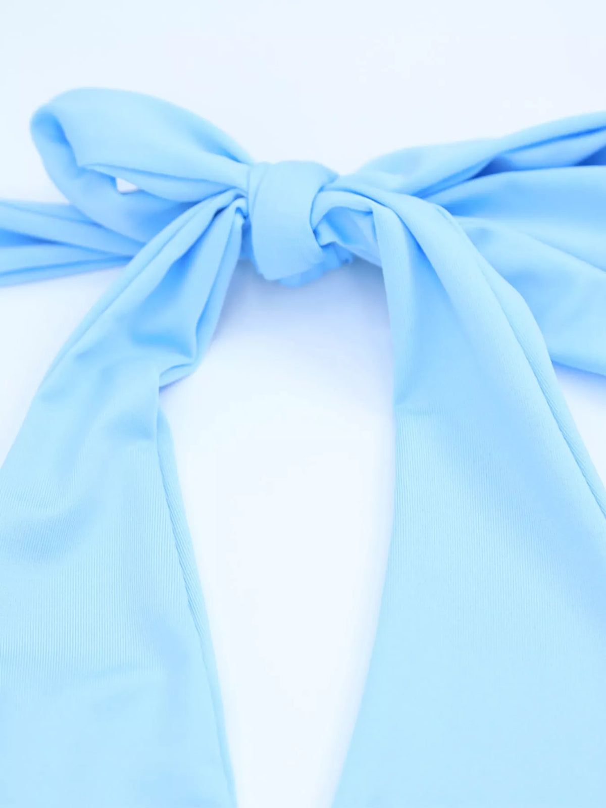 Blue halter crop top and ruched bodycon mini skirt set, close-up of the halter tie