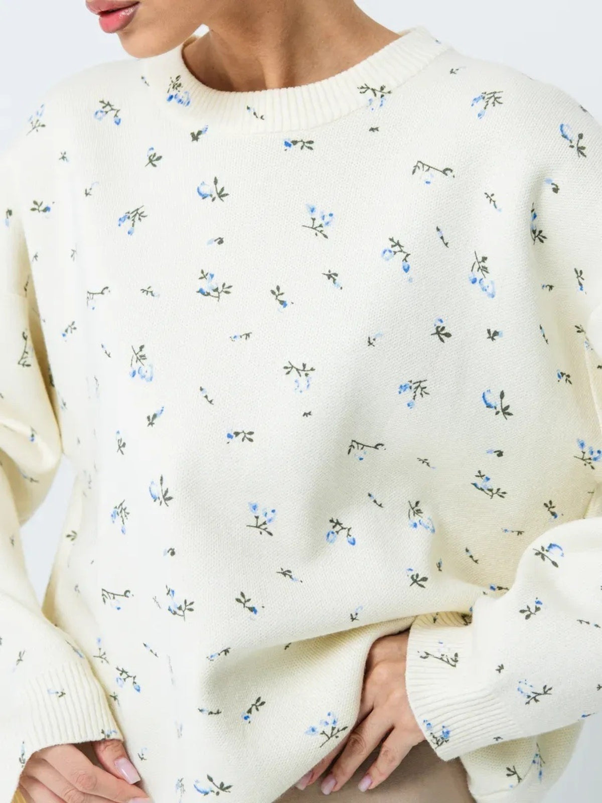 White floral dropped-shoulder oversized sweater, neckline and floral detail.