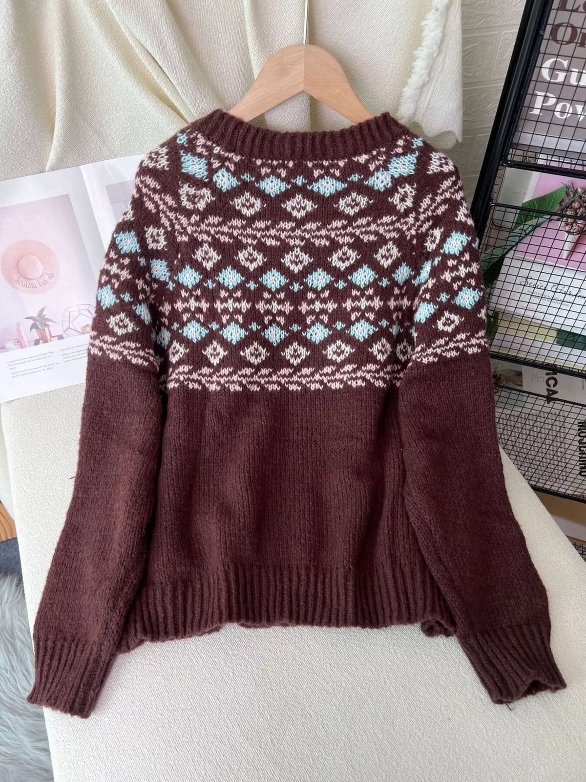 Brown fair isle round-neck sweater, back on hanger.