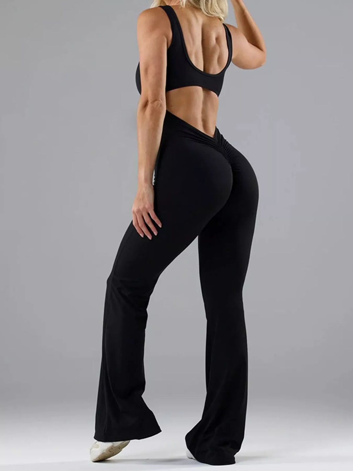 Black scoop-neck flared-leg active jumpsuit, back cutout view.