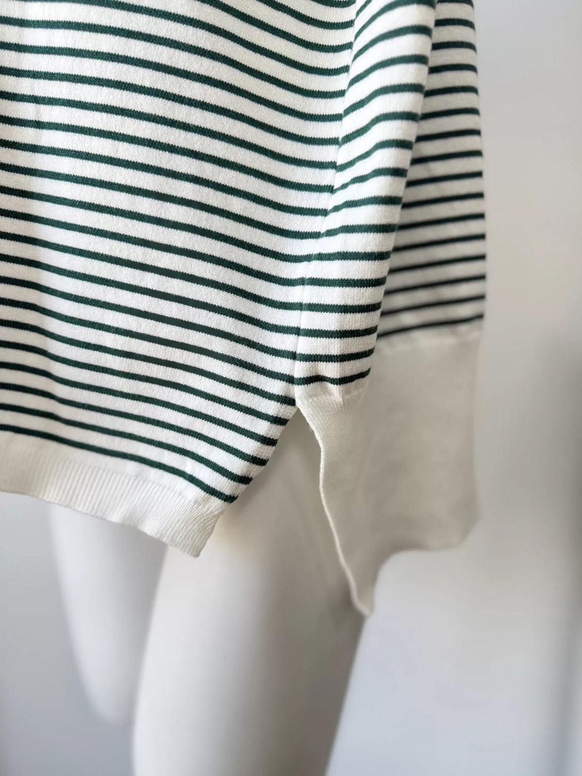 Striped round-neck knit top in white and green, ribbed hem detail