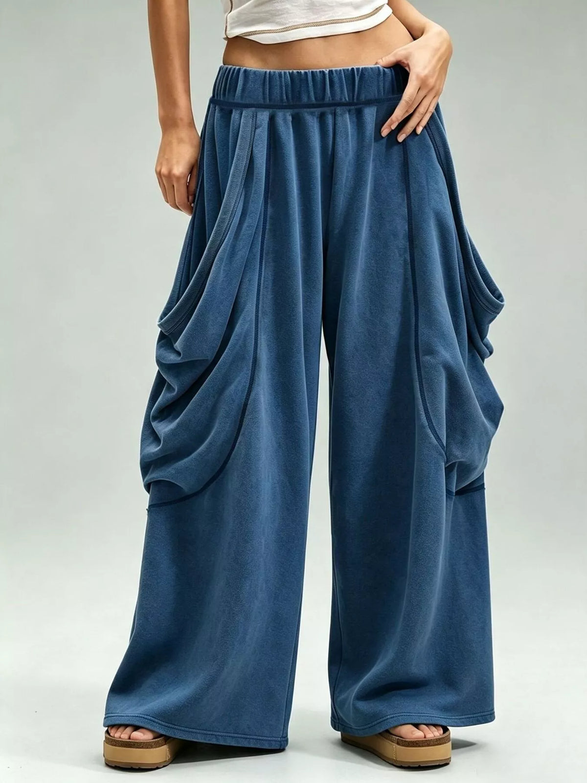 Blue wide-leg cargo pants, front view with hand at waist