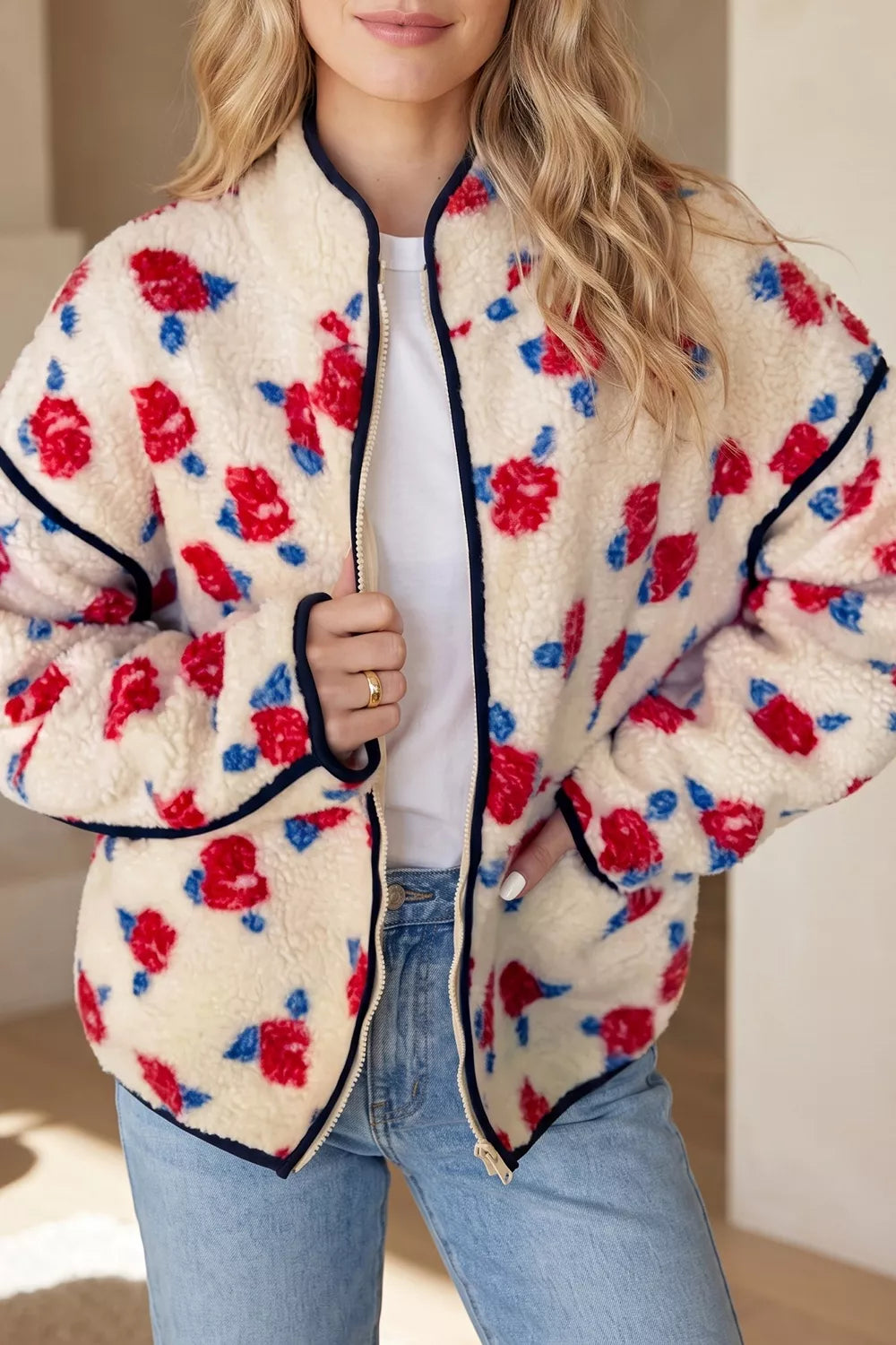Cream with red flowers floral zip-up fleece jacket, front view.