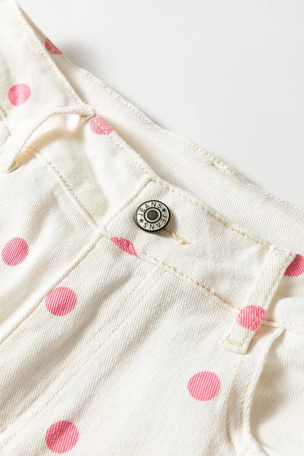White with pink dots polka-dot cropped jeans, waistband and button close-up