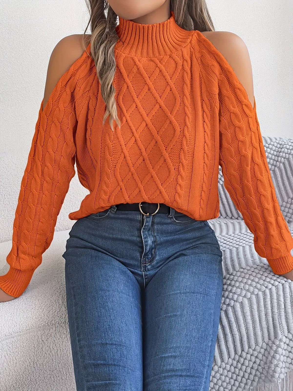 Orange cold-shoulder cable-knit sweater, front with arms extended.