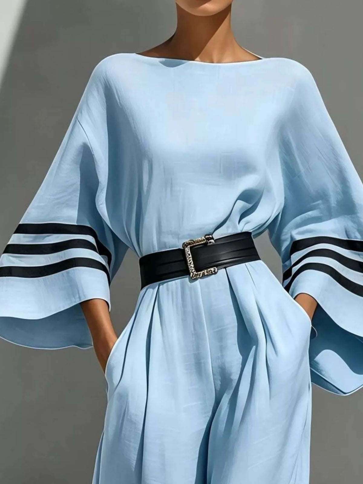 Light blue wide-sleeve jumpsuit with striped trim, bodice and waist detail.