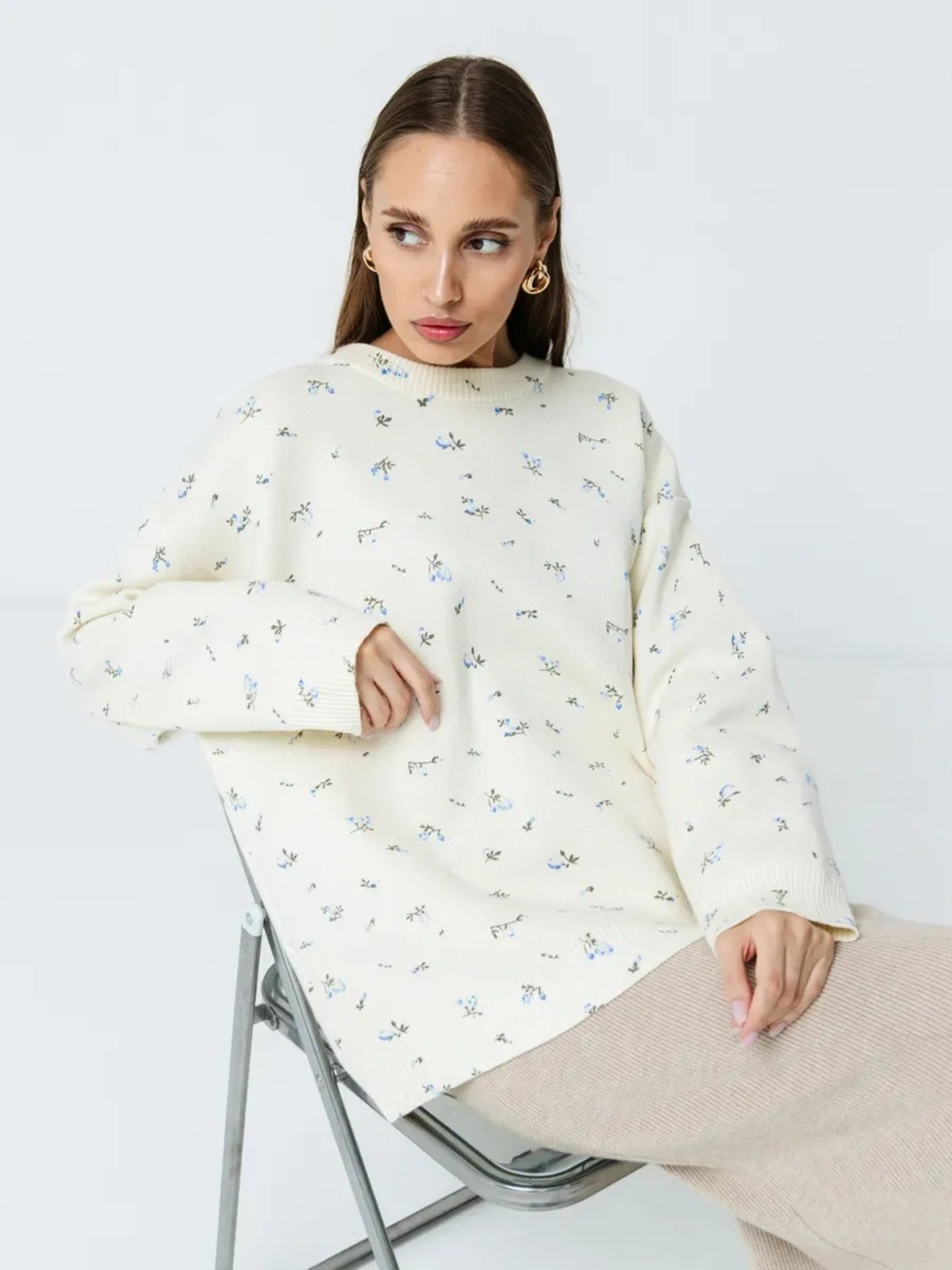 White floral dropped-shoulder oversized sweater, seated front view.