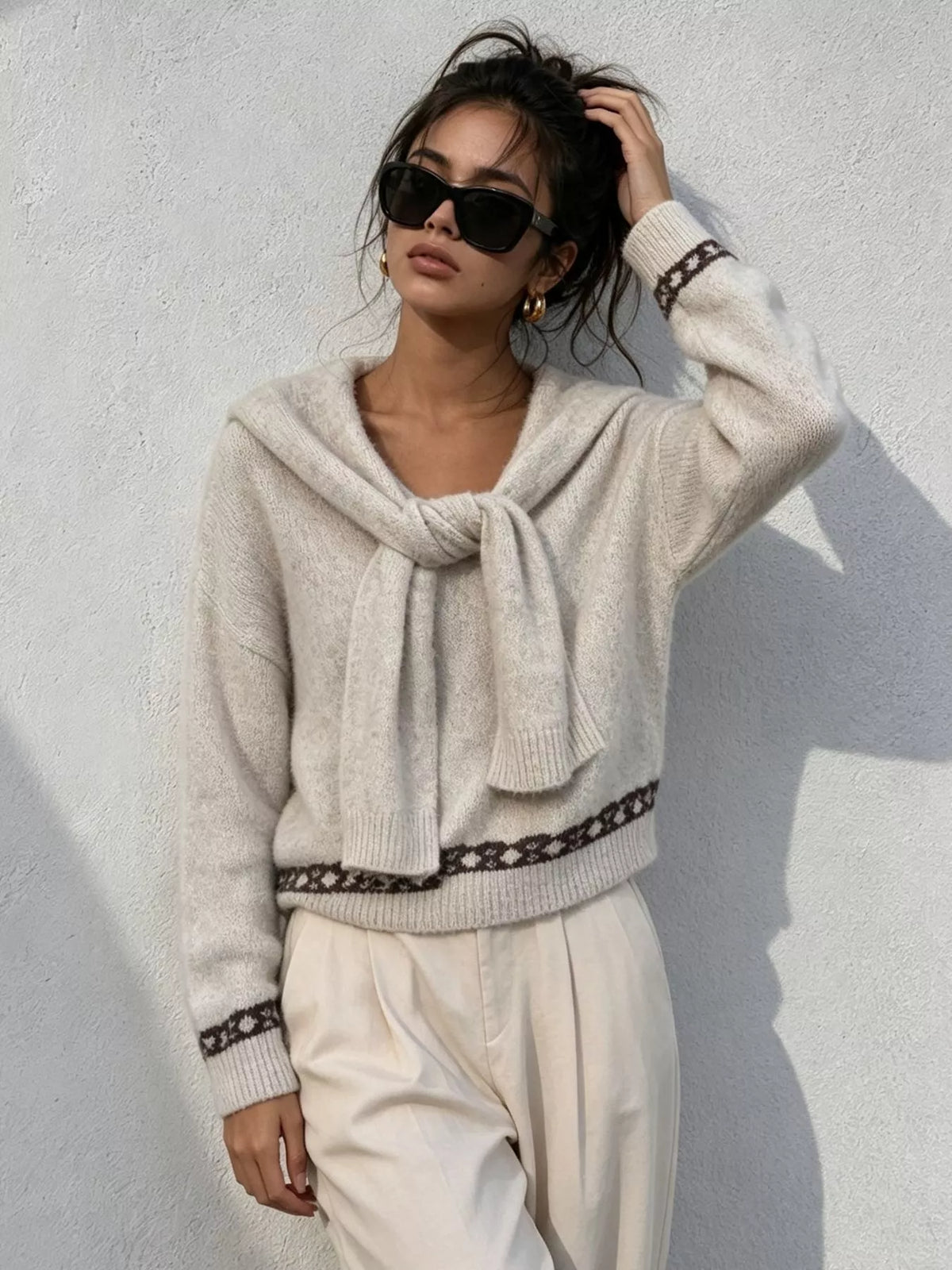 Ivory scarf-detail dropped-shoulder sweater, front with raised hand.