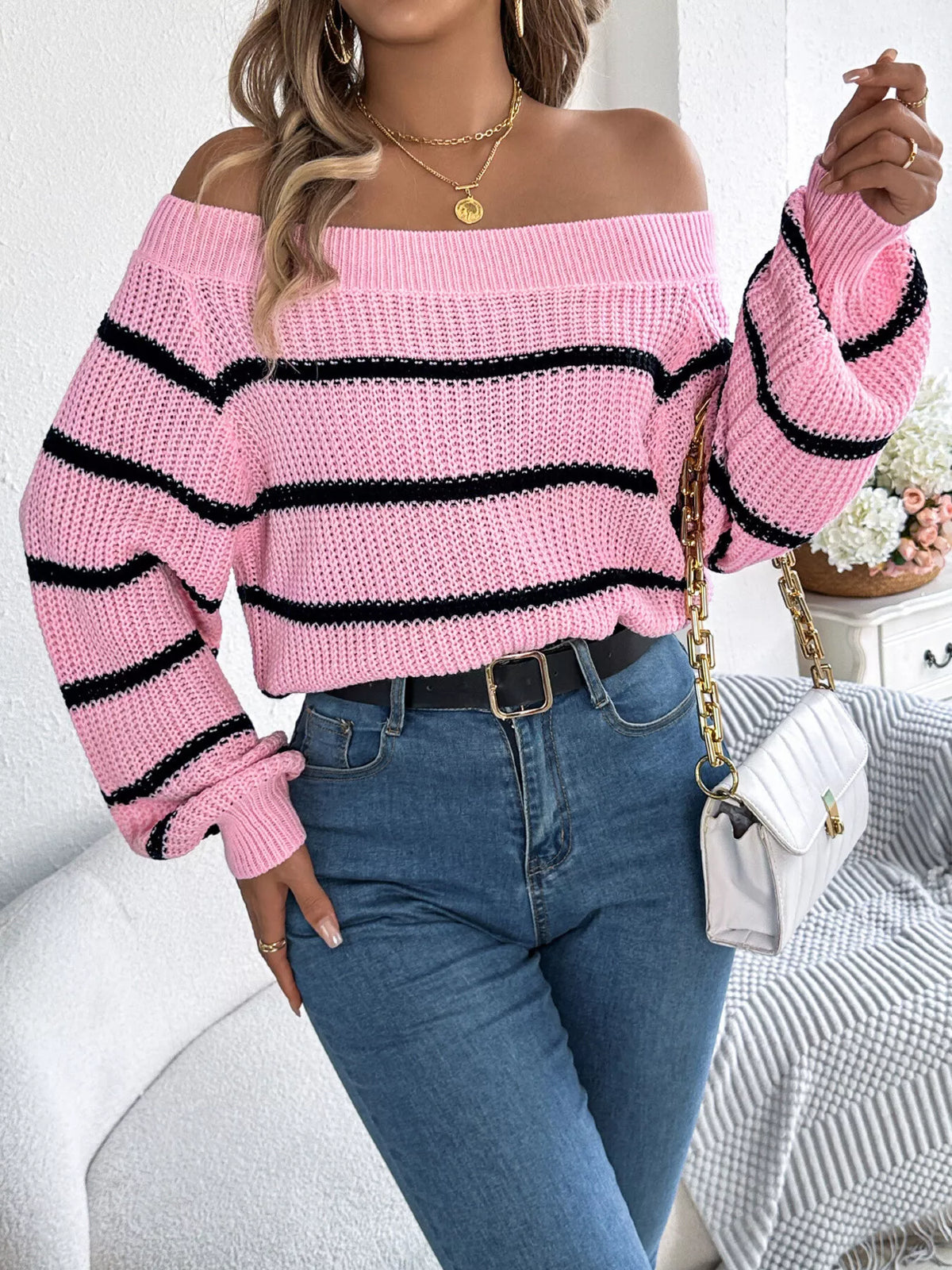 Pink off-shoulder striped sweater, front with raised hand.