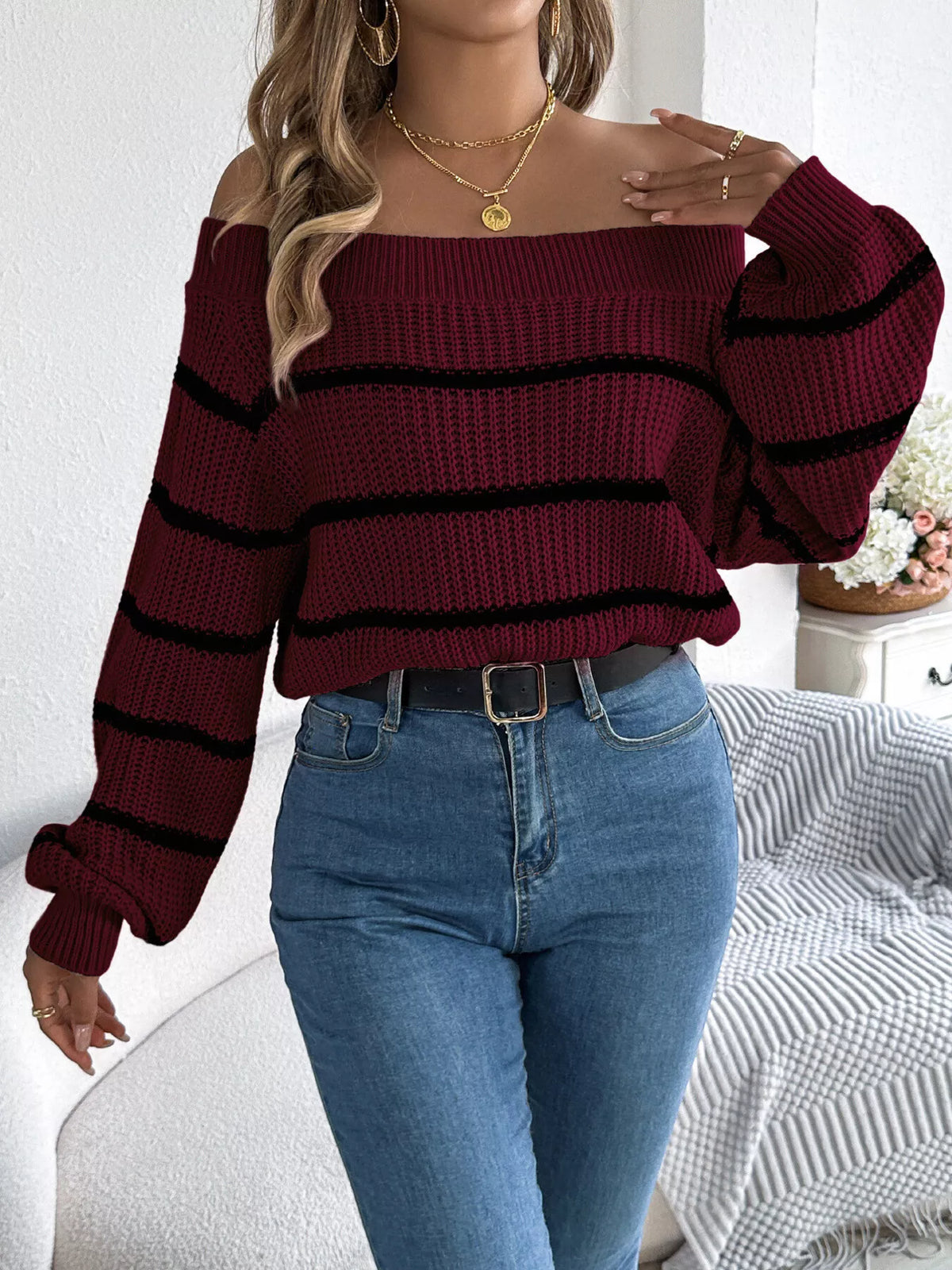 Burgundy off-shoulder striped sweater, front with hand at neckline.