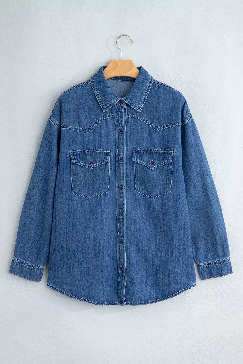 Blue western pocket denim tunic shirt, front on hanger