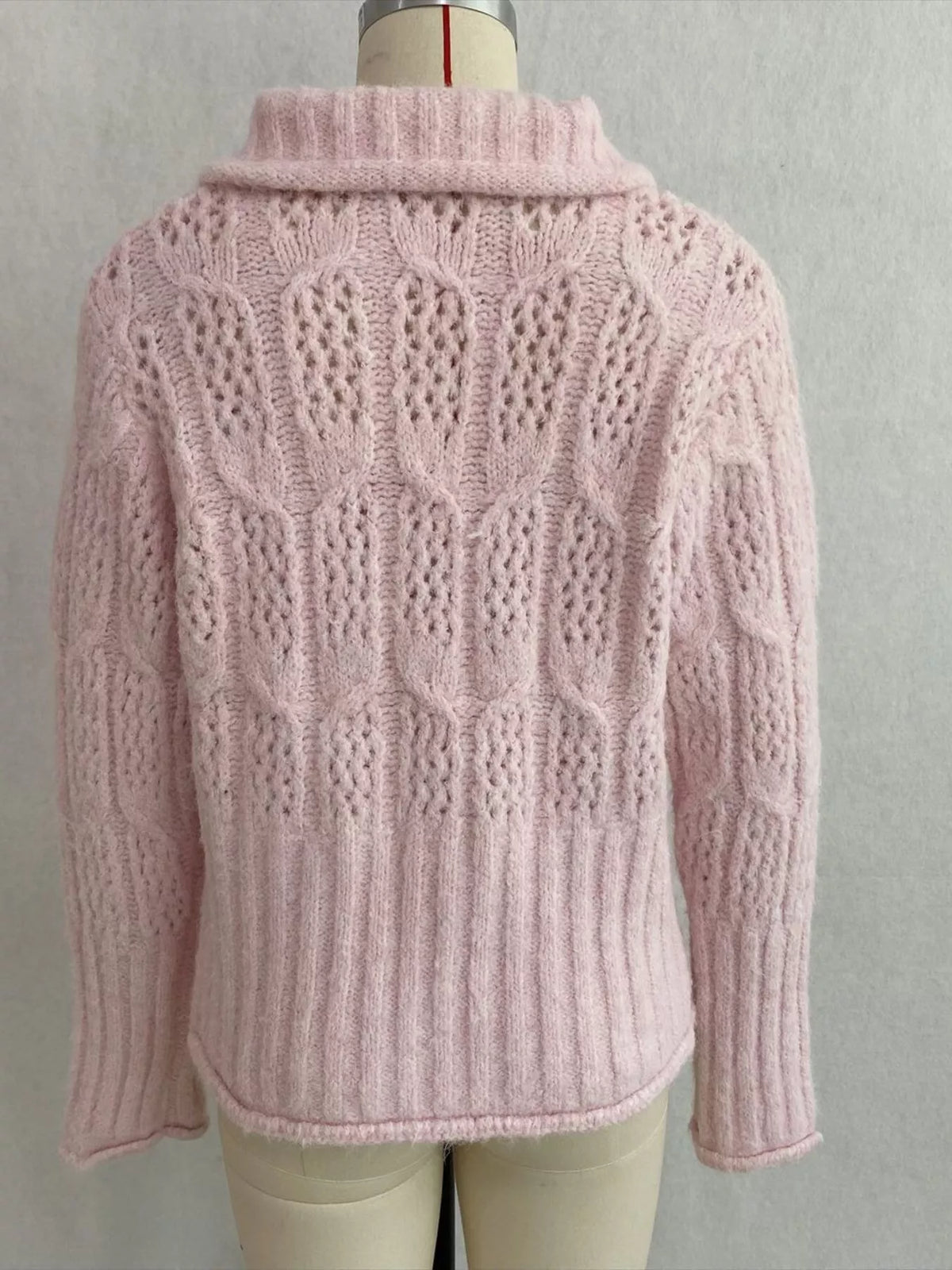 Pink cable-knit collared button-front cardigan, back on dress form.