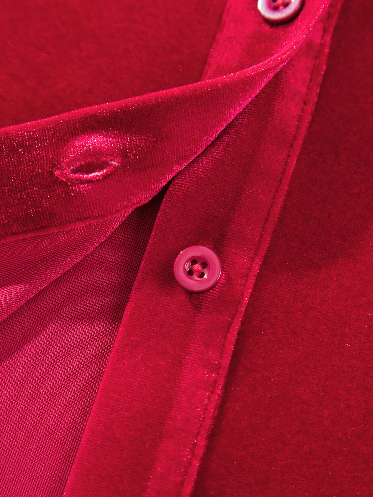 Button closure on red velvet button-down shirt with patch pockets