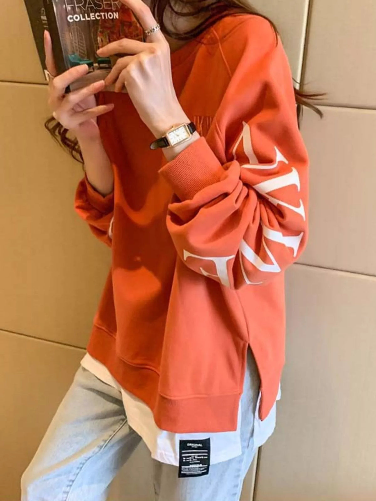 Orange layered-hem sweatshirt with graphic sleeve detail