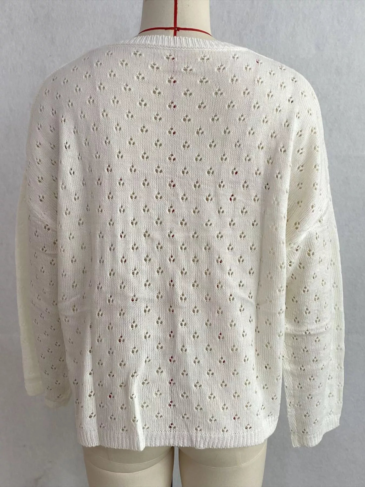White pointelle round-neck knit top, back on dress form.