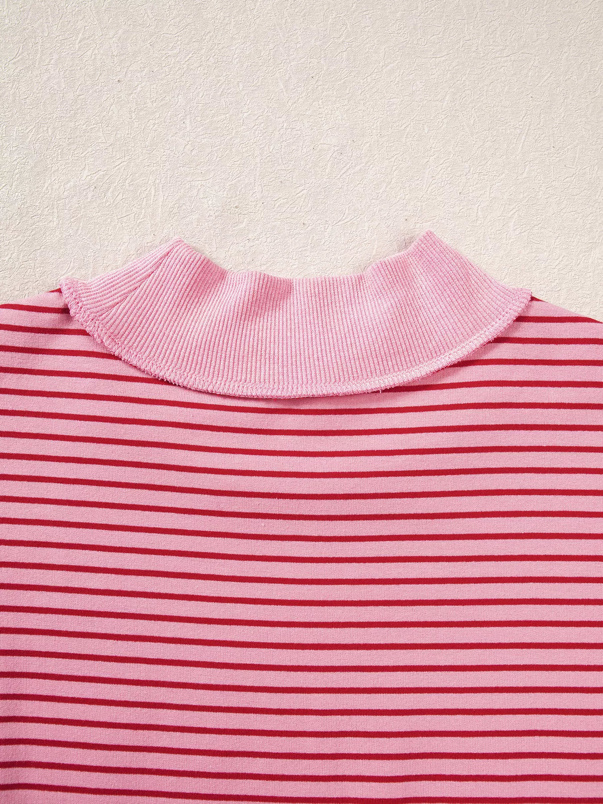 Back neckline on pink and red striped striped color-block mock neck sweatshirt