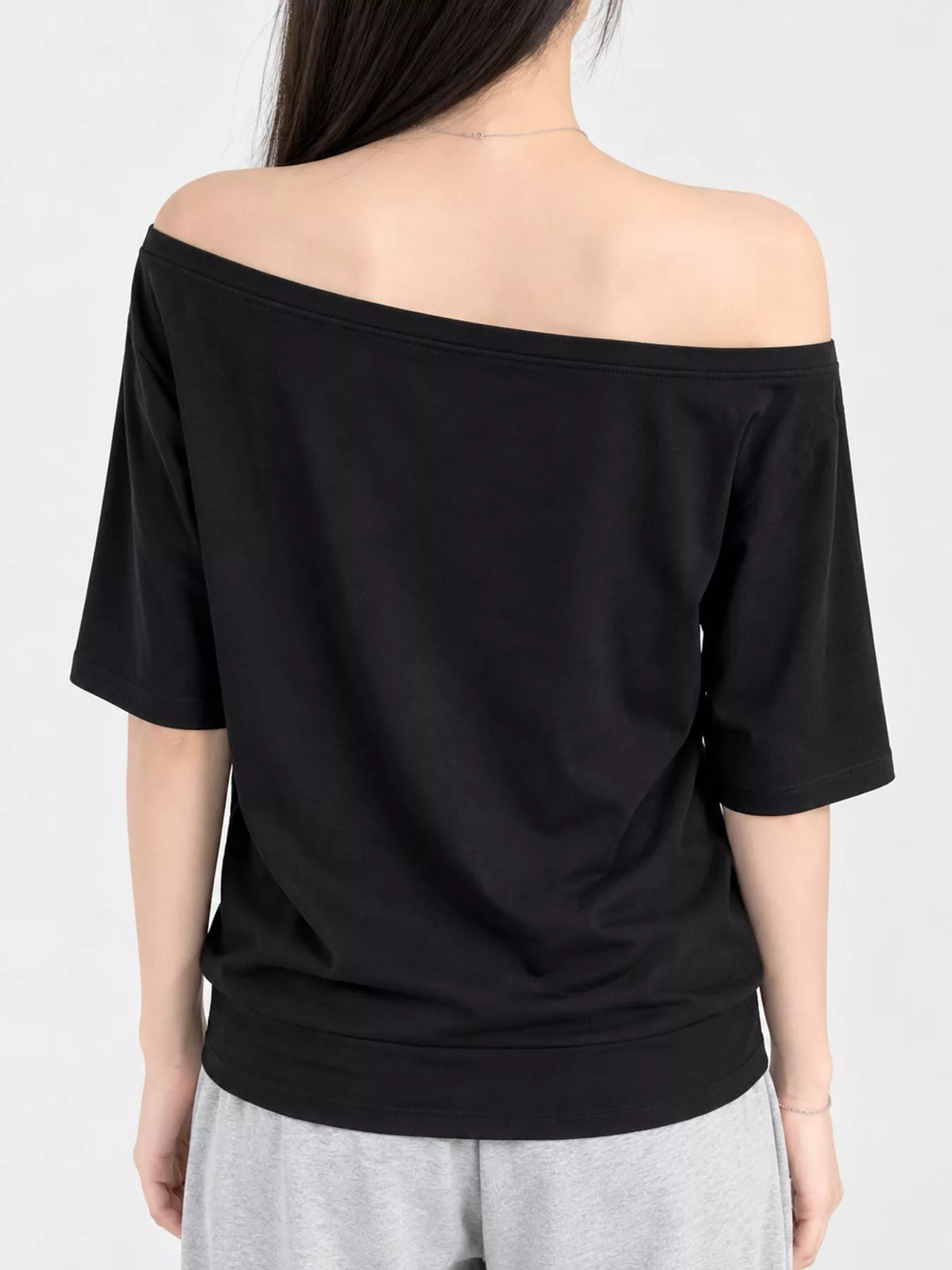 Black asymmetric-neck T-shirt, back view