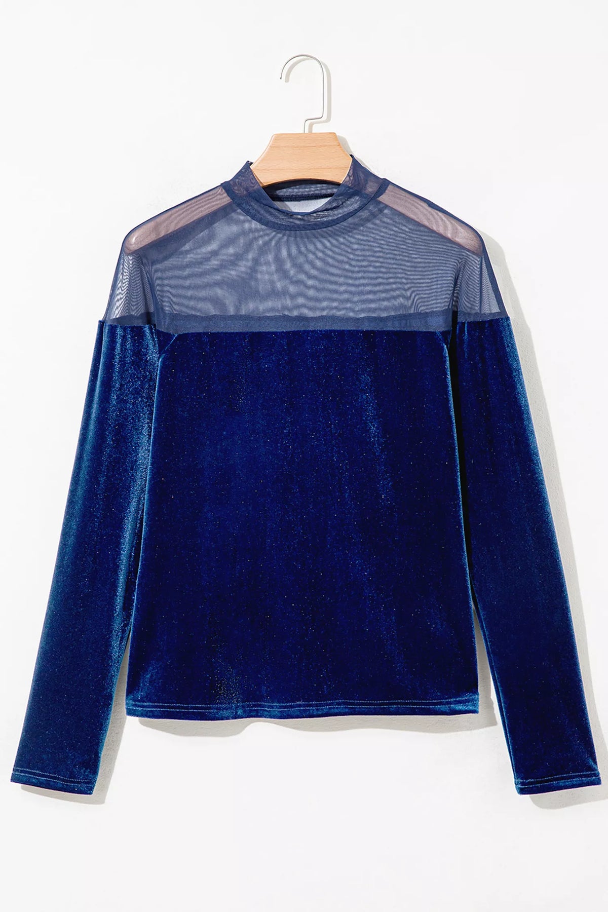 Navy velvet top with sheer yoke and long sleeves, front on hanger.