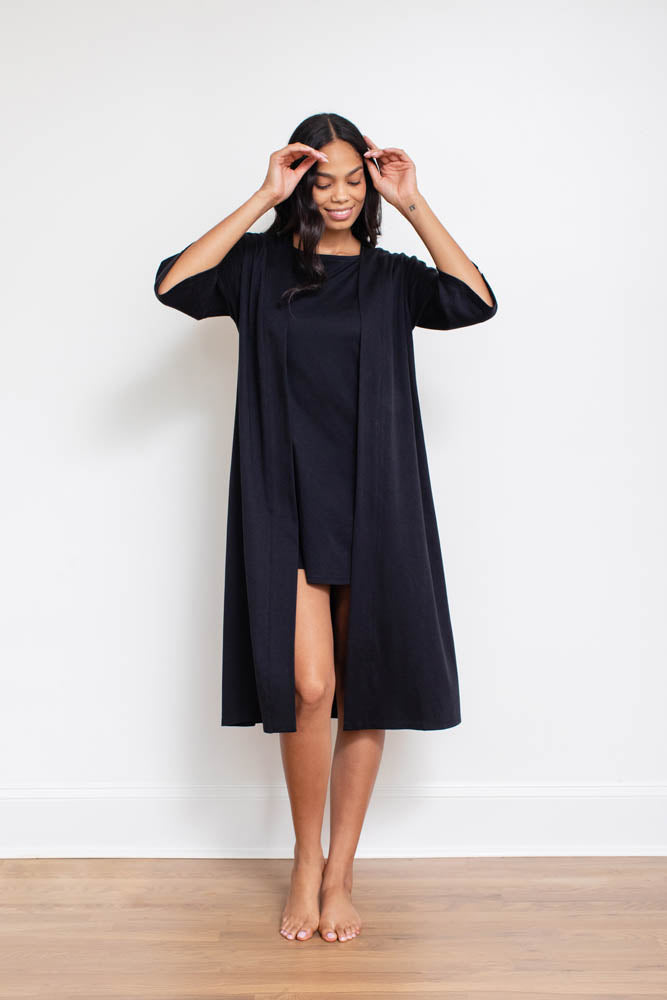 Black Pima cotton robe worn open over a dress, full-length view