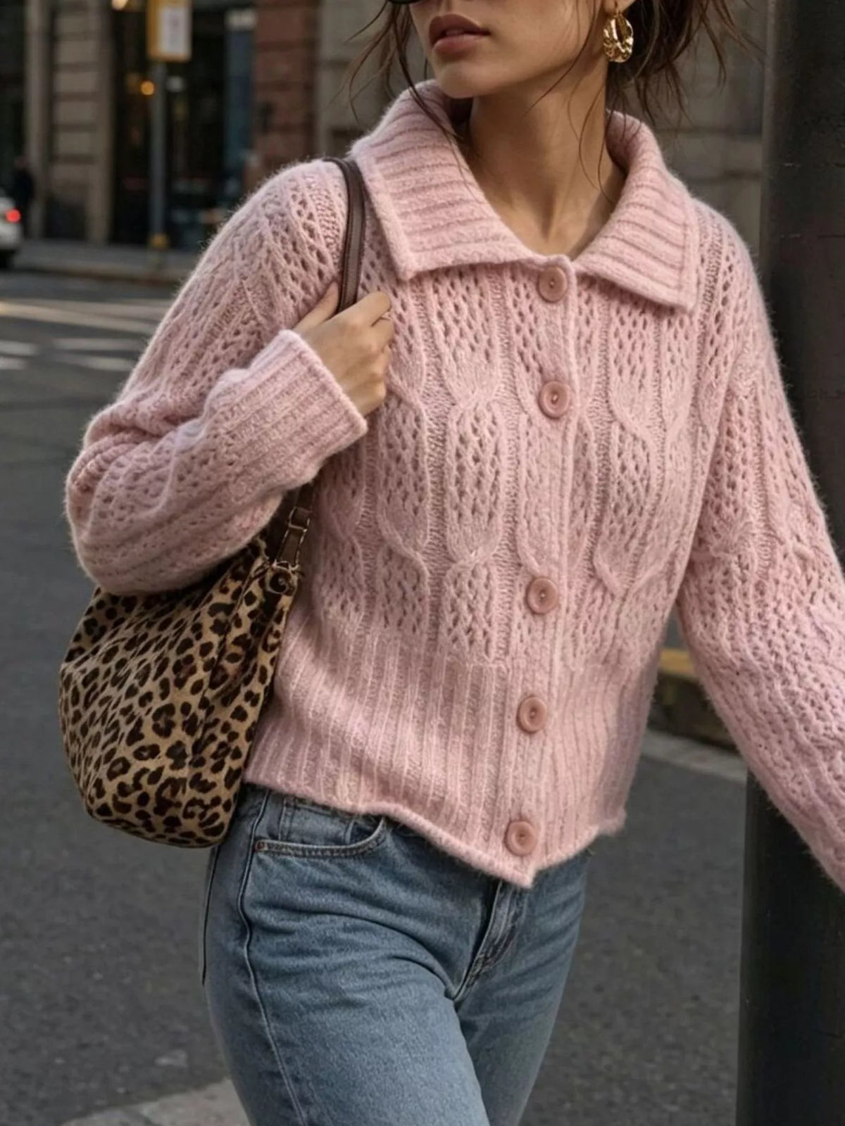 Pink cable-knit collared button-front cardigan, walking front view.
