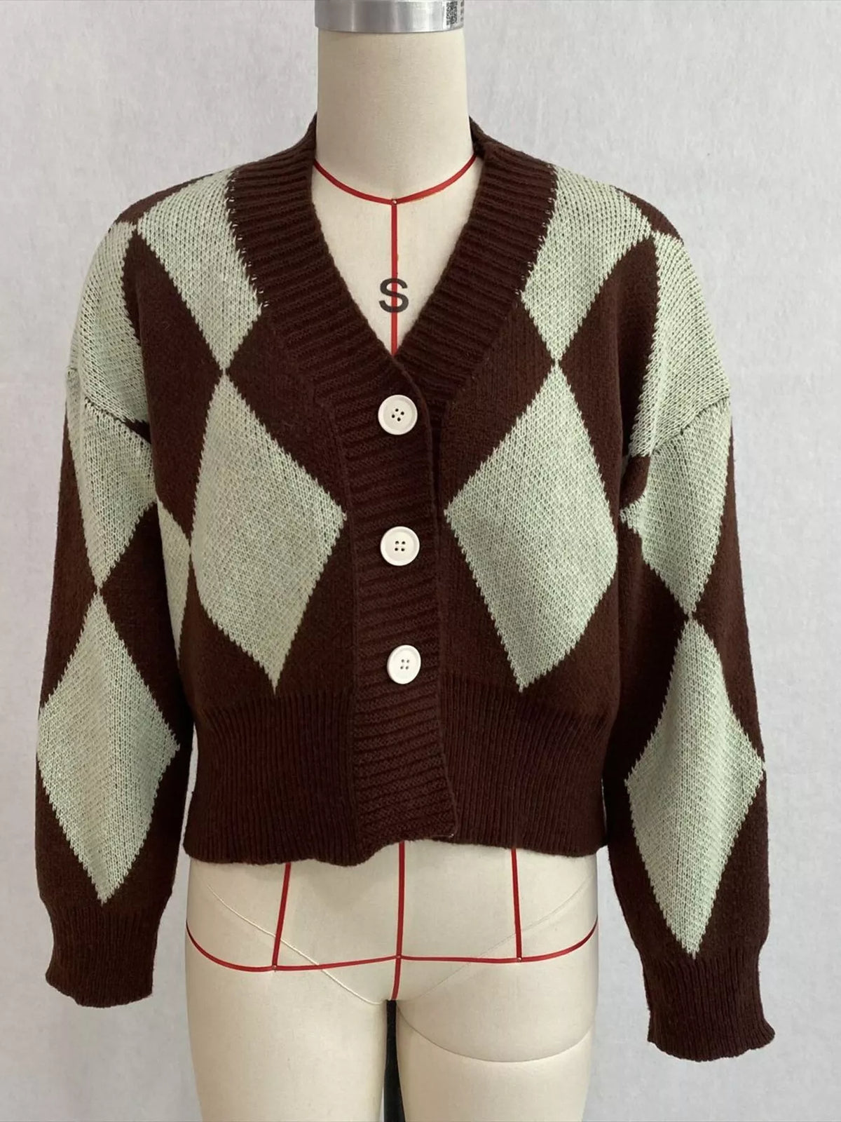 Brown and green argyle v-neck button-front cardigan, front on dress form.