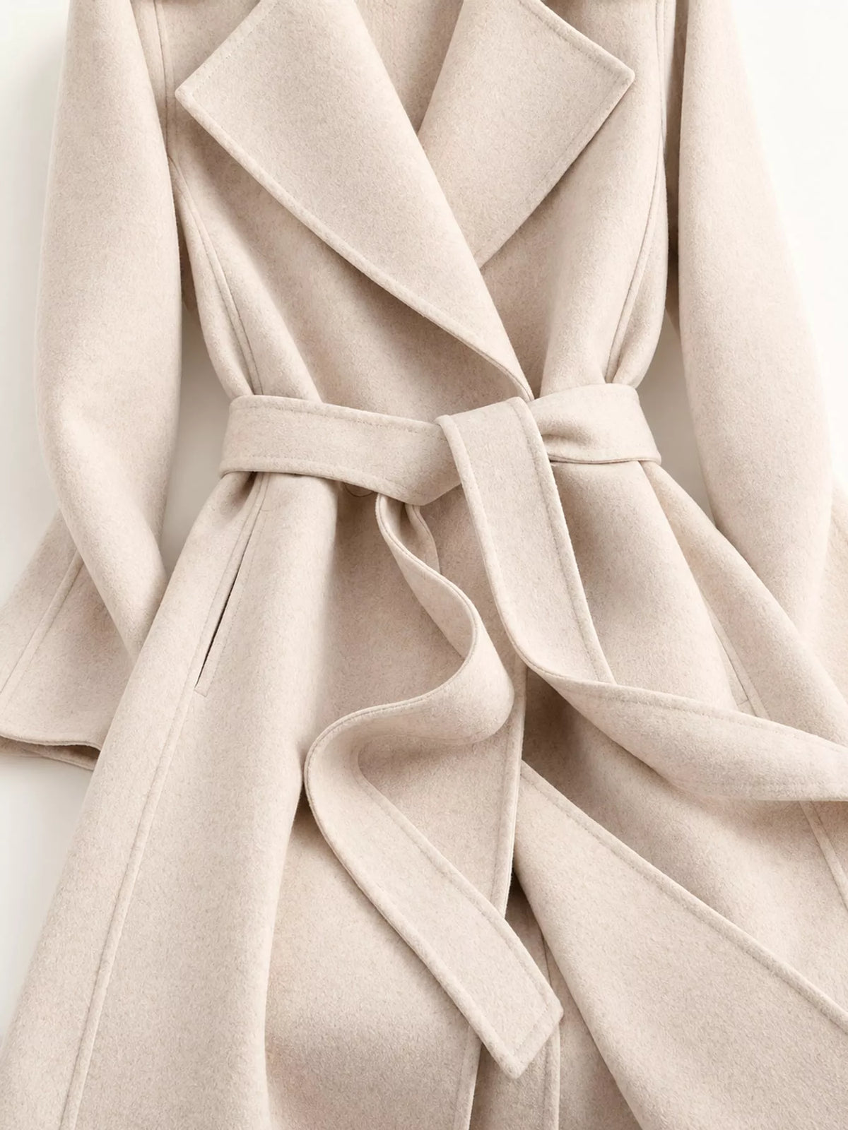 Cream belted longline wool coat, lapels and tied waist