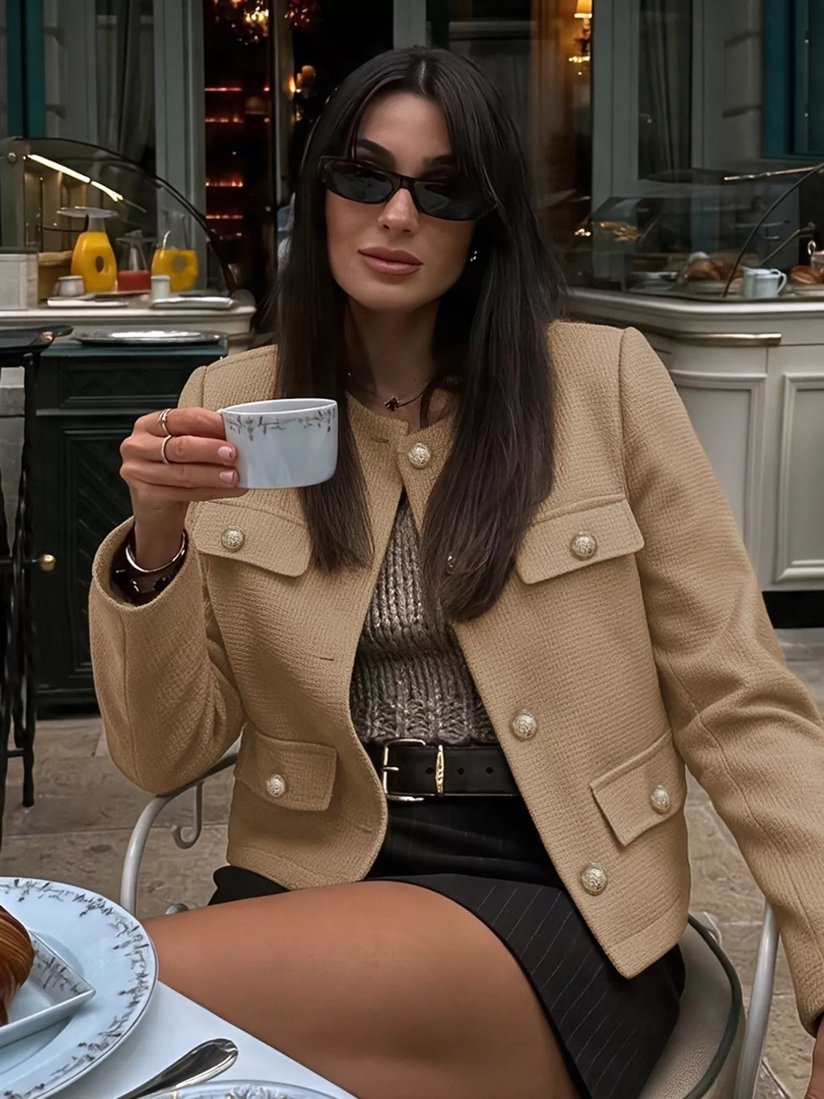 Tan textured cropped jacket with gold-tone buttons, seated view