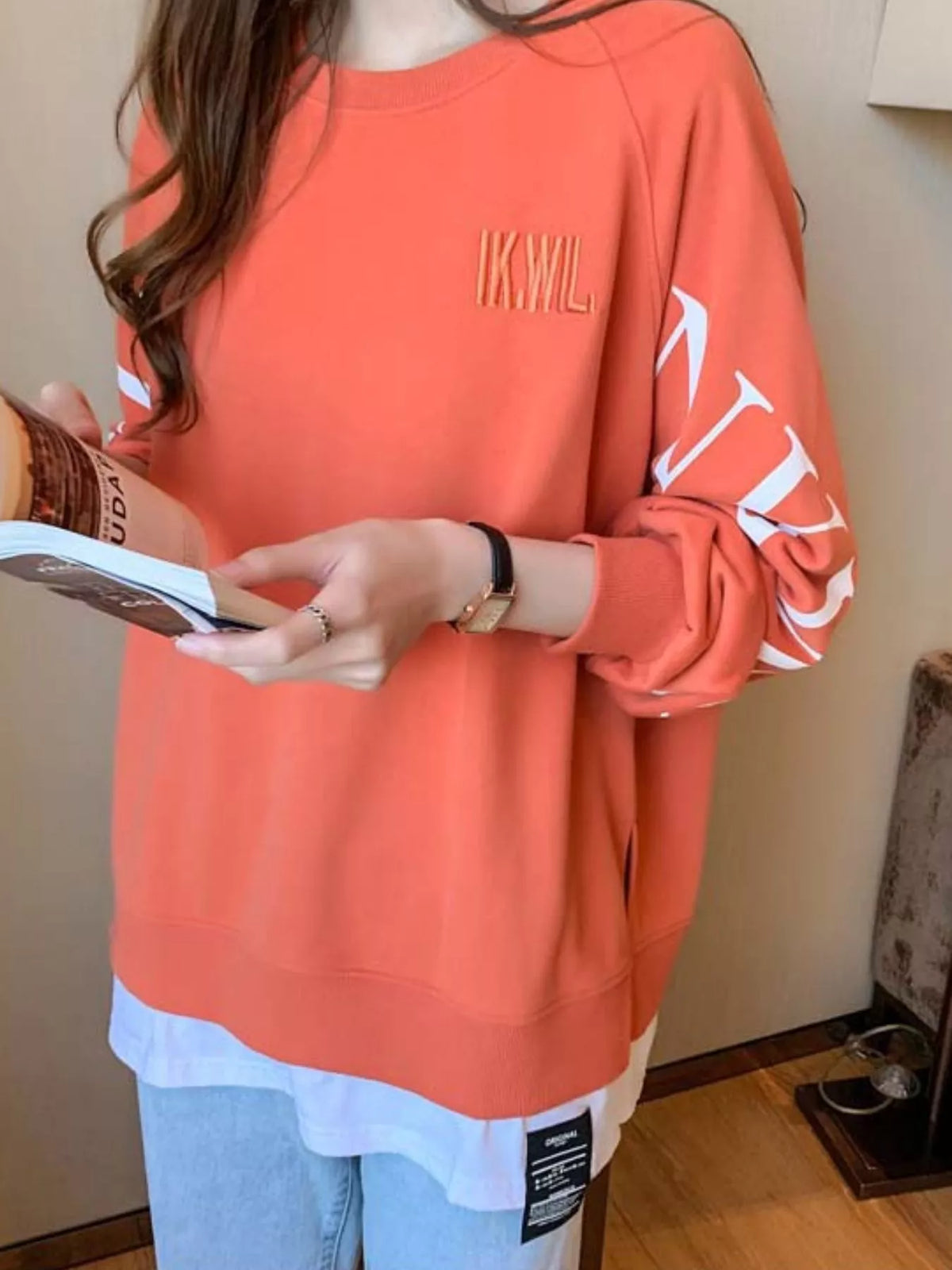 Orange layered-hem sweatshirt with graphic sleeve detail