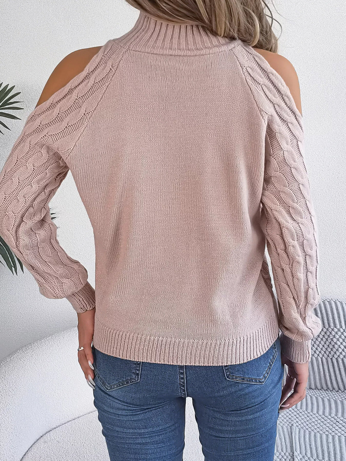 Pink cold-shoulder cable-knit sweater, back view.