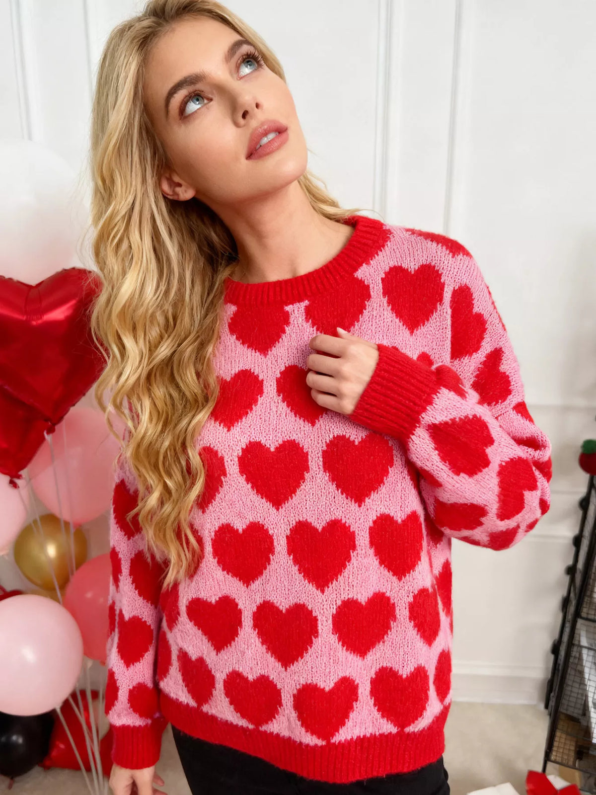 Pink and red allover heart dropped-shoulder sweater, front view showing heart pattern.