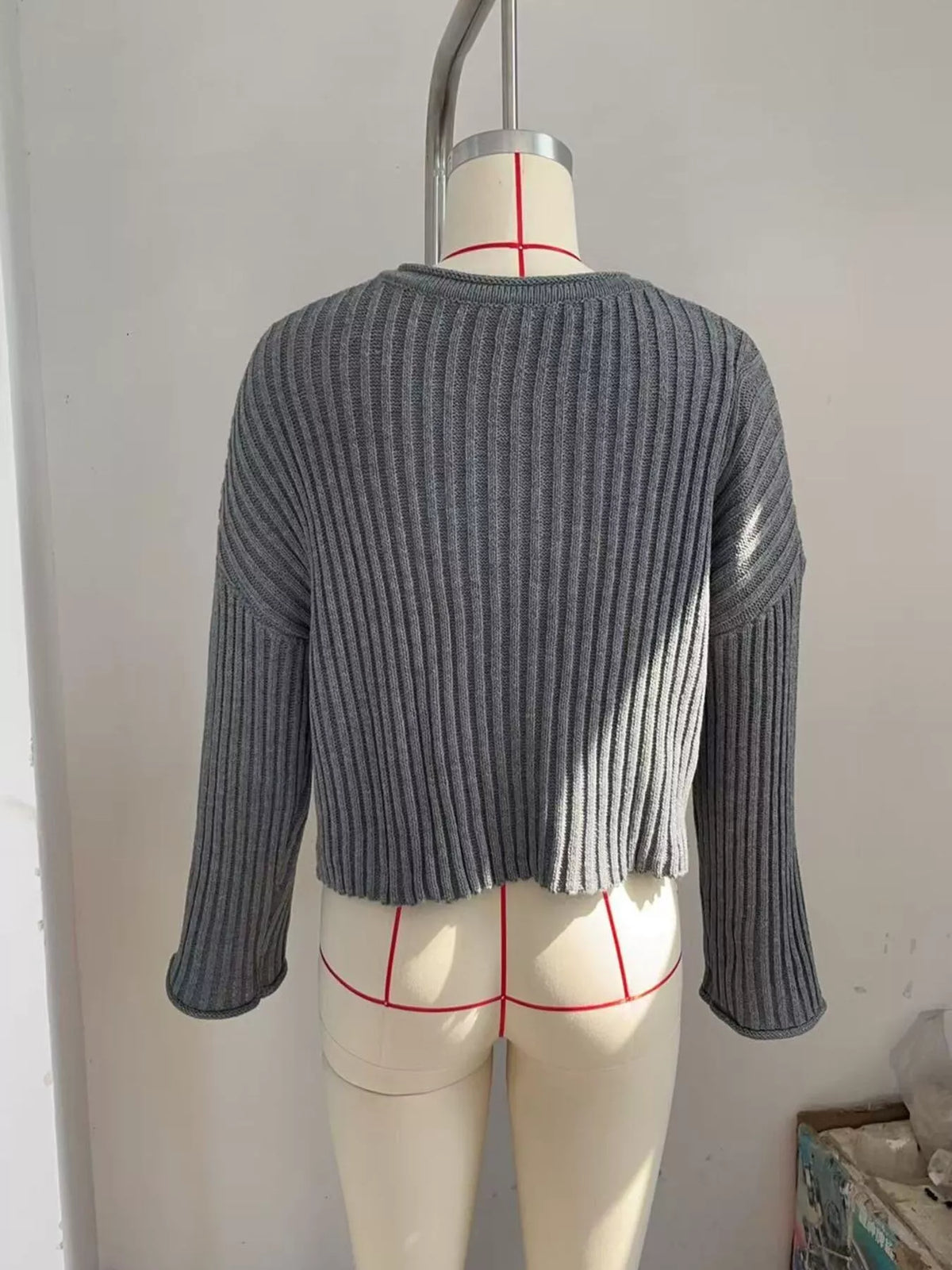 Gray ribbed lace-up cropped sweater, back on dress form.