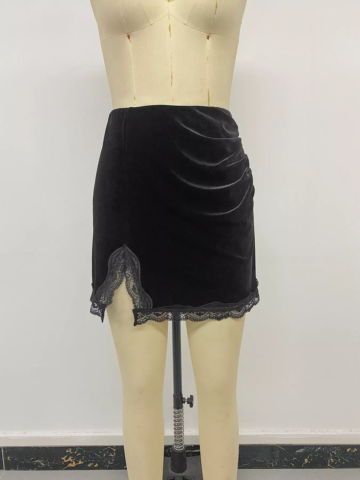 Black velvet mini skirt with lace trim, front on mannequin