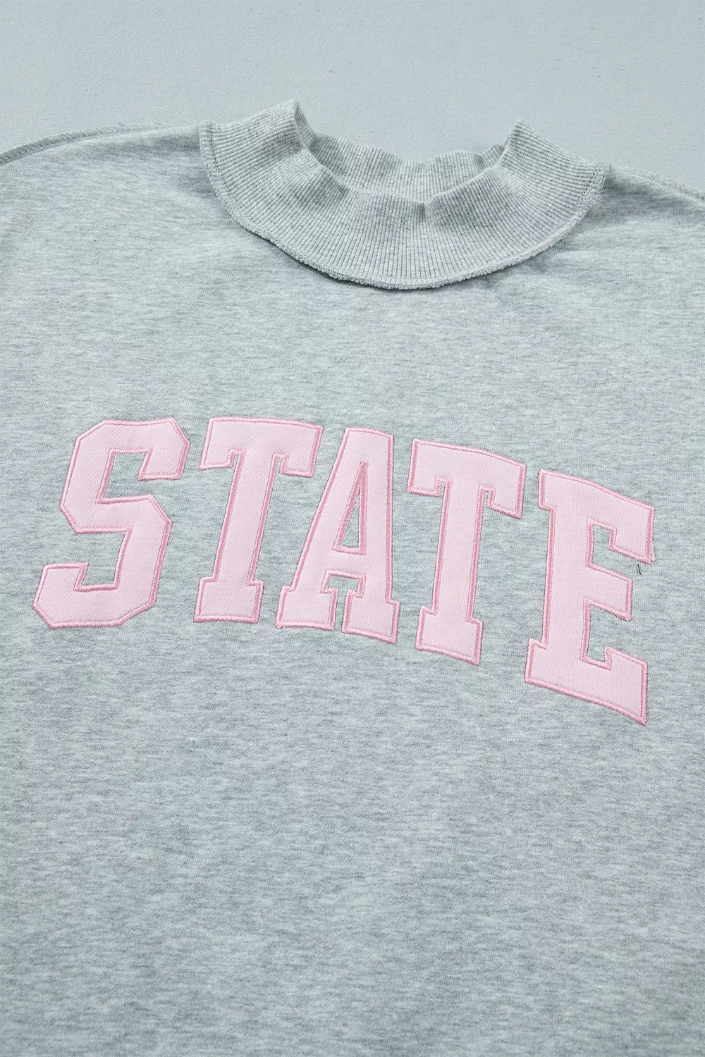 STATE Graphic Exposed Seam Mock Neck Sweatshirt in gray, neckline and lettering detail