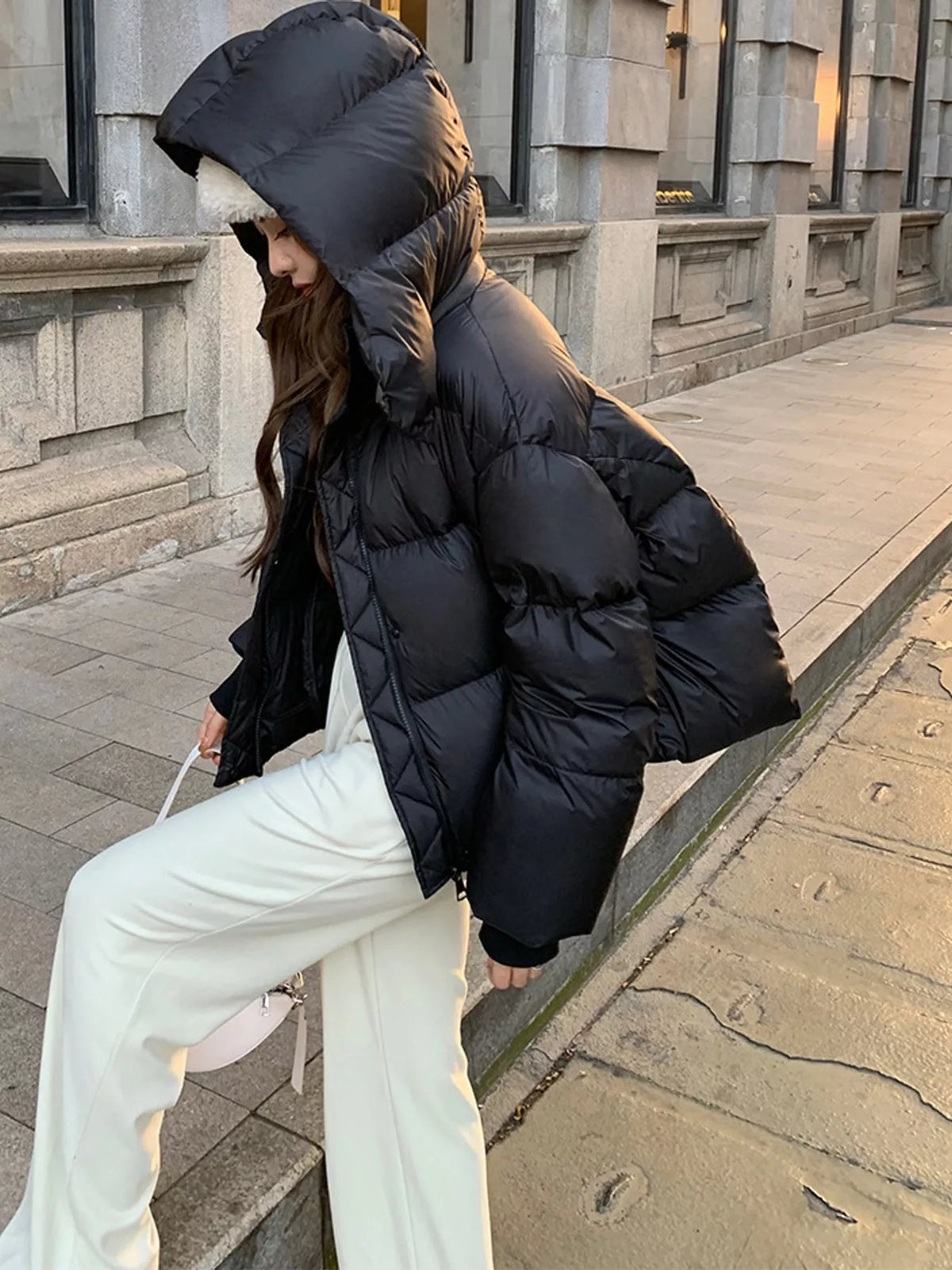 Black quilted hooded puffer jacket, side view with hood up
