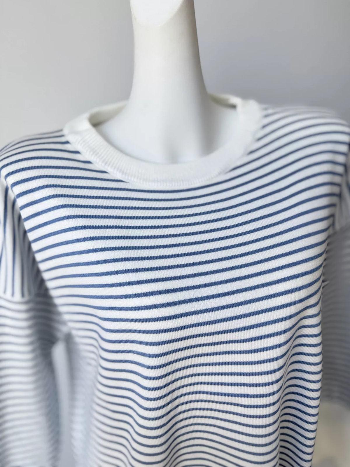 Striped round-neck knit top in white and blue, neckline detail