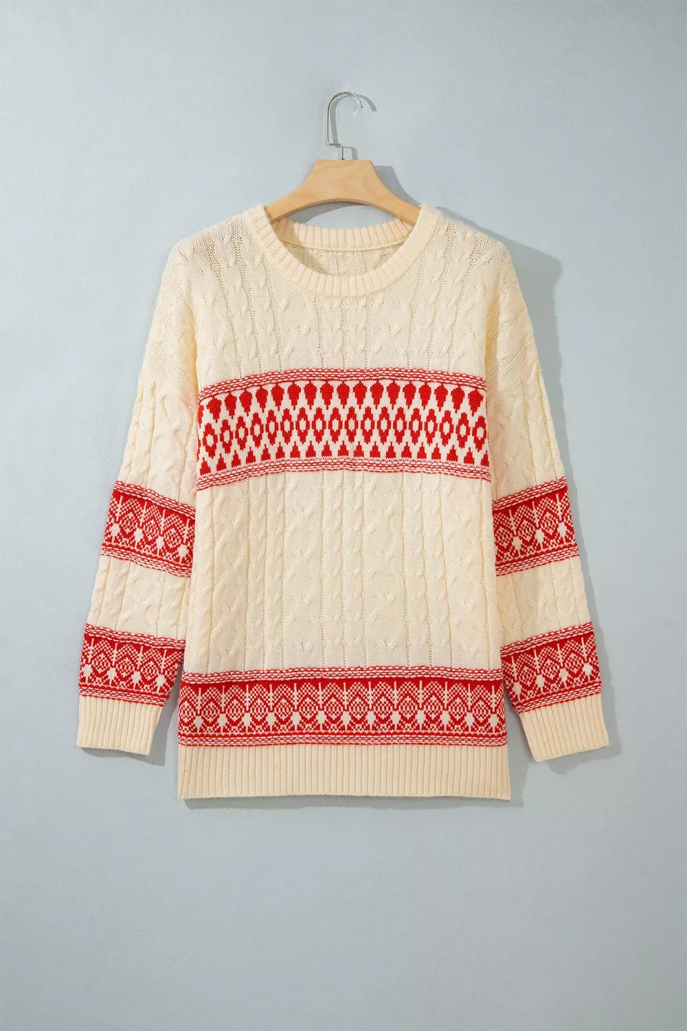 Ivory geometric cable-knit crewneck sweater, front on hanger.