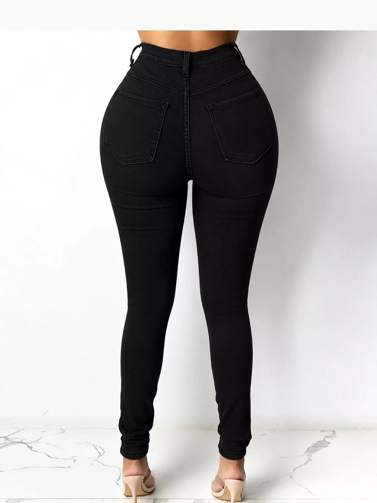 Black high-waisted skinny jeans, back view