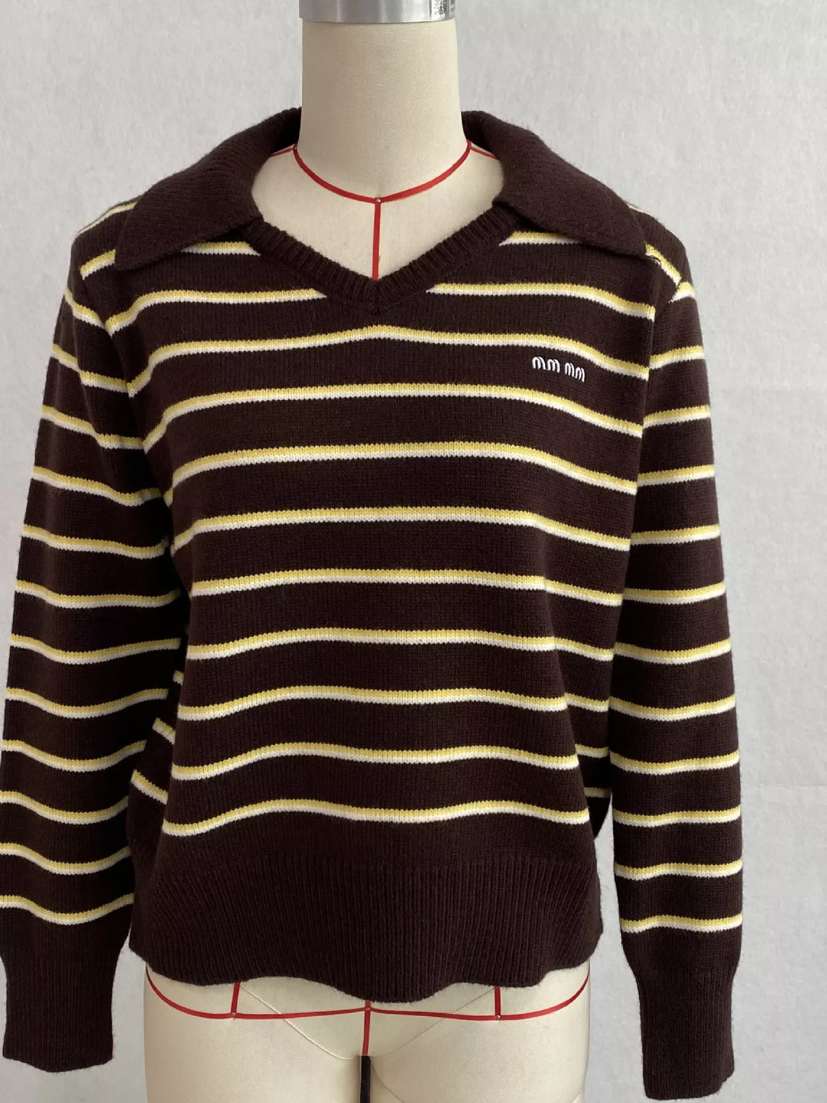 Brown and cream striped polo-collar sweater, front on dress form.