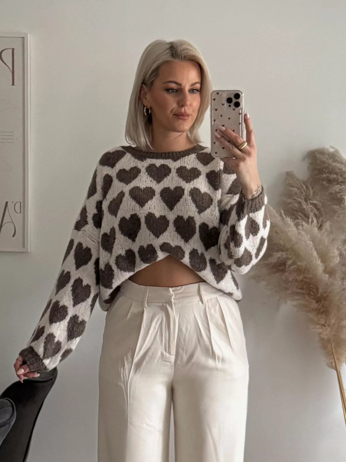 Cream and brown allover heart dropped-shoulder sweater, front showing wide sleeves.