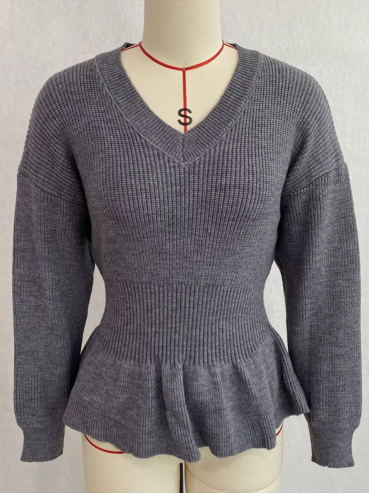 Gray v-neck peplum-hem knit sweater, front on dress form.
