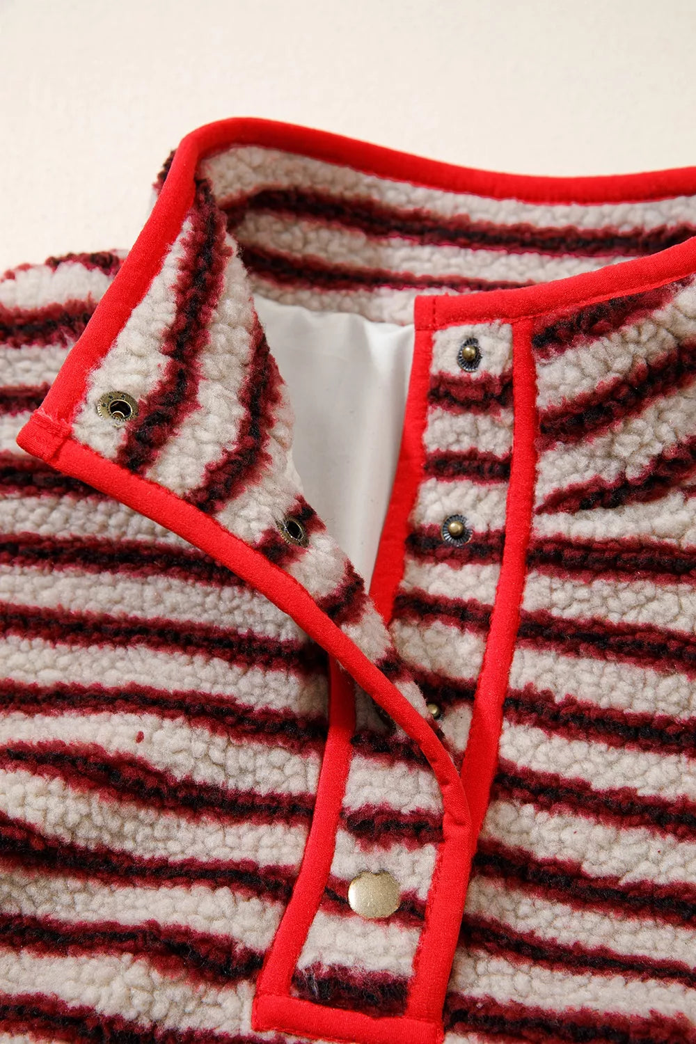 Red and cream striped fuzzy snap-placket sweatshirt, snap placket close-up