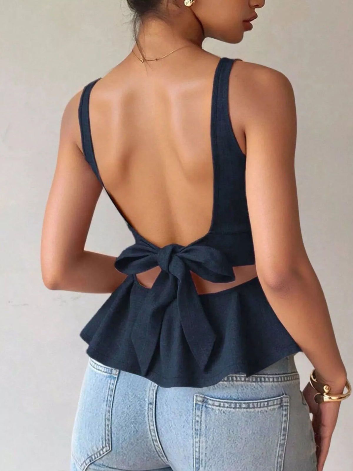 Navy open-back bow-tie peplum tank top, back view.
