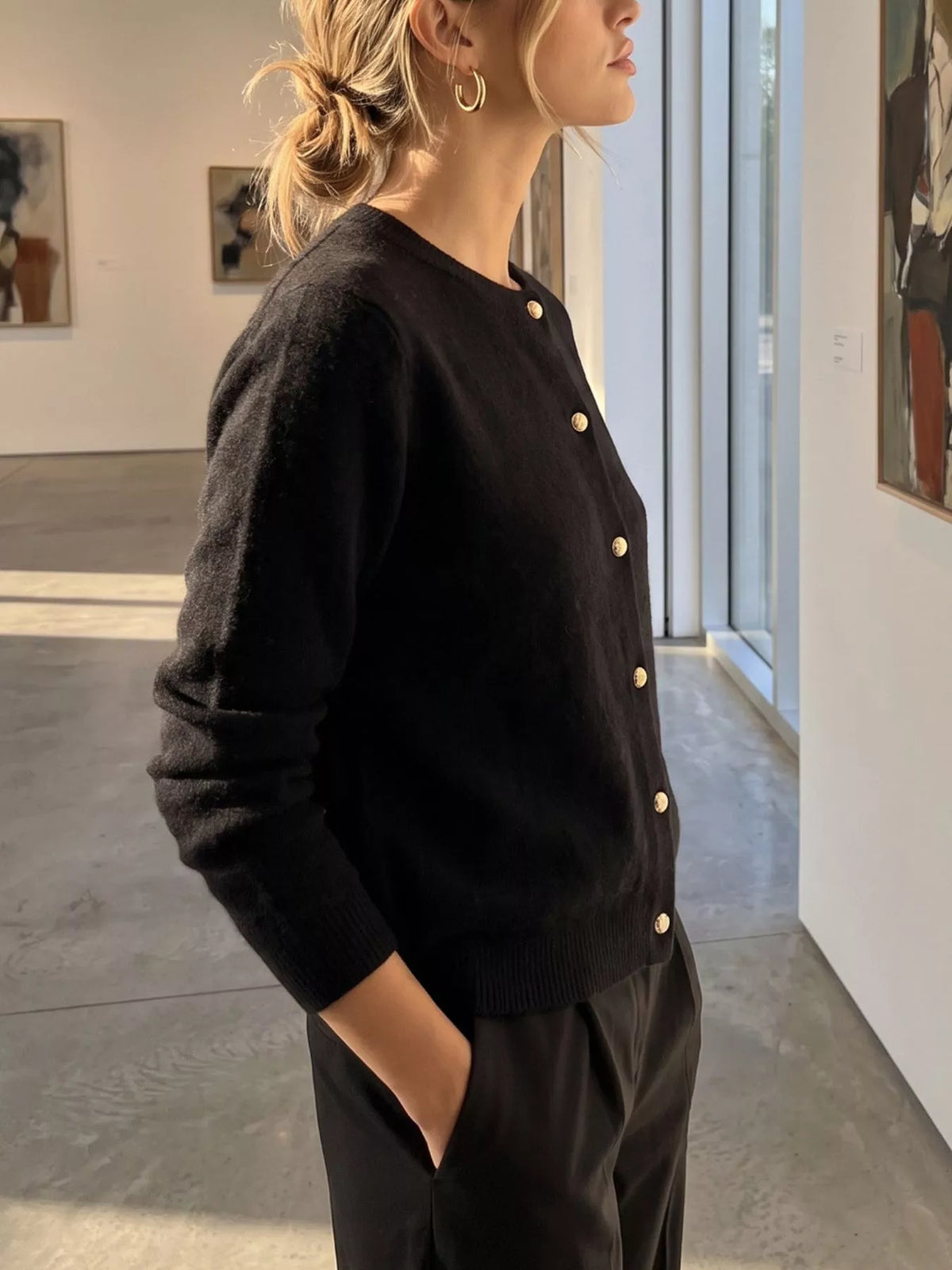 Black round-neck button-front knit cardigan, side view.