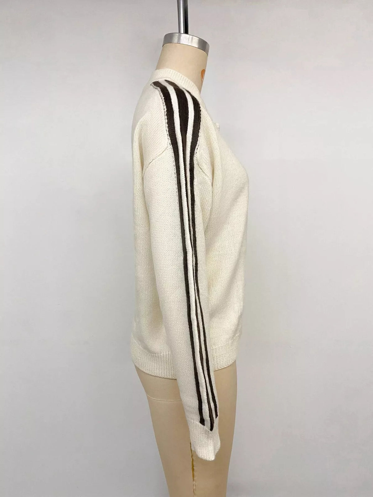 Cream Chinese knot button cardigan with sleeve stripes, side on mannequin